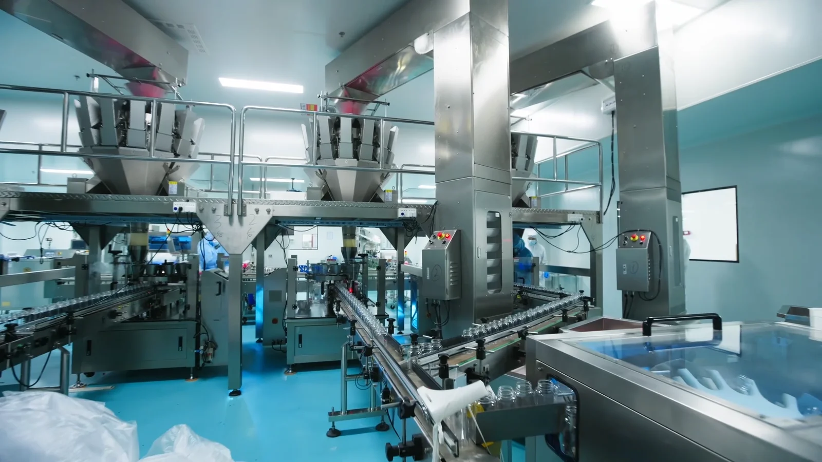 Gummy manufacturing equipment and connected conveyors inside a production workshop, illustrating the manufacturing setting for magnesium glycinate gummy development and packaging projects.