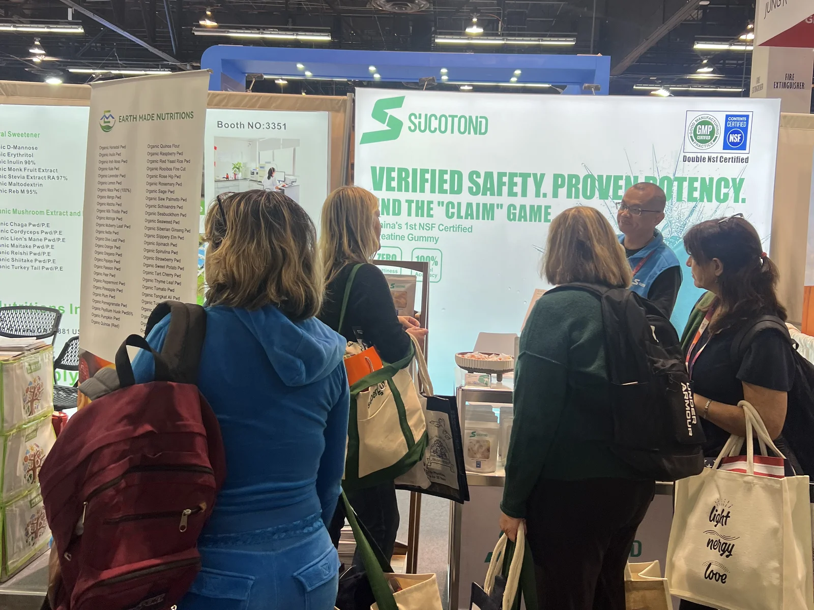 Visitors gather around the SUCOTOND representative and gummy product display