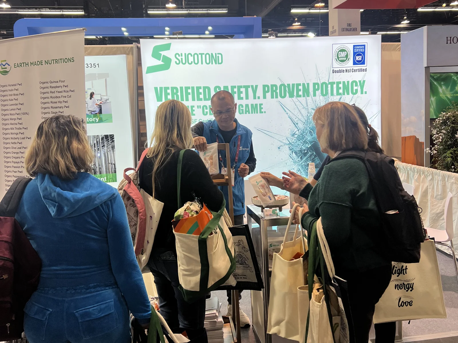 A SUCOTOND representative shows packaged gummy samples to visitors