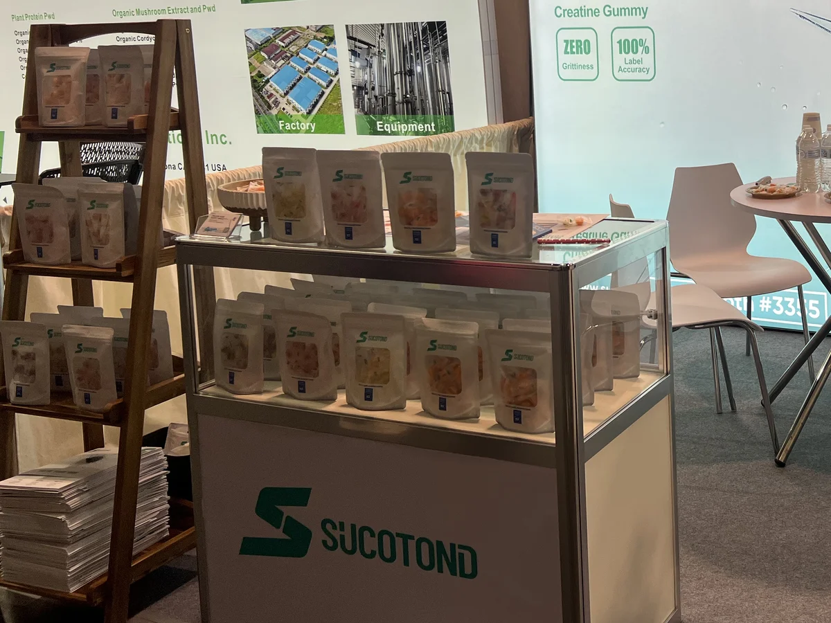 Packaged gummy pouches displayed on shelves and in the SUCOTOND booth showcase