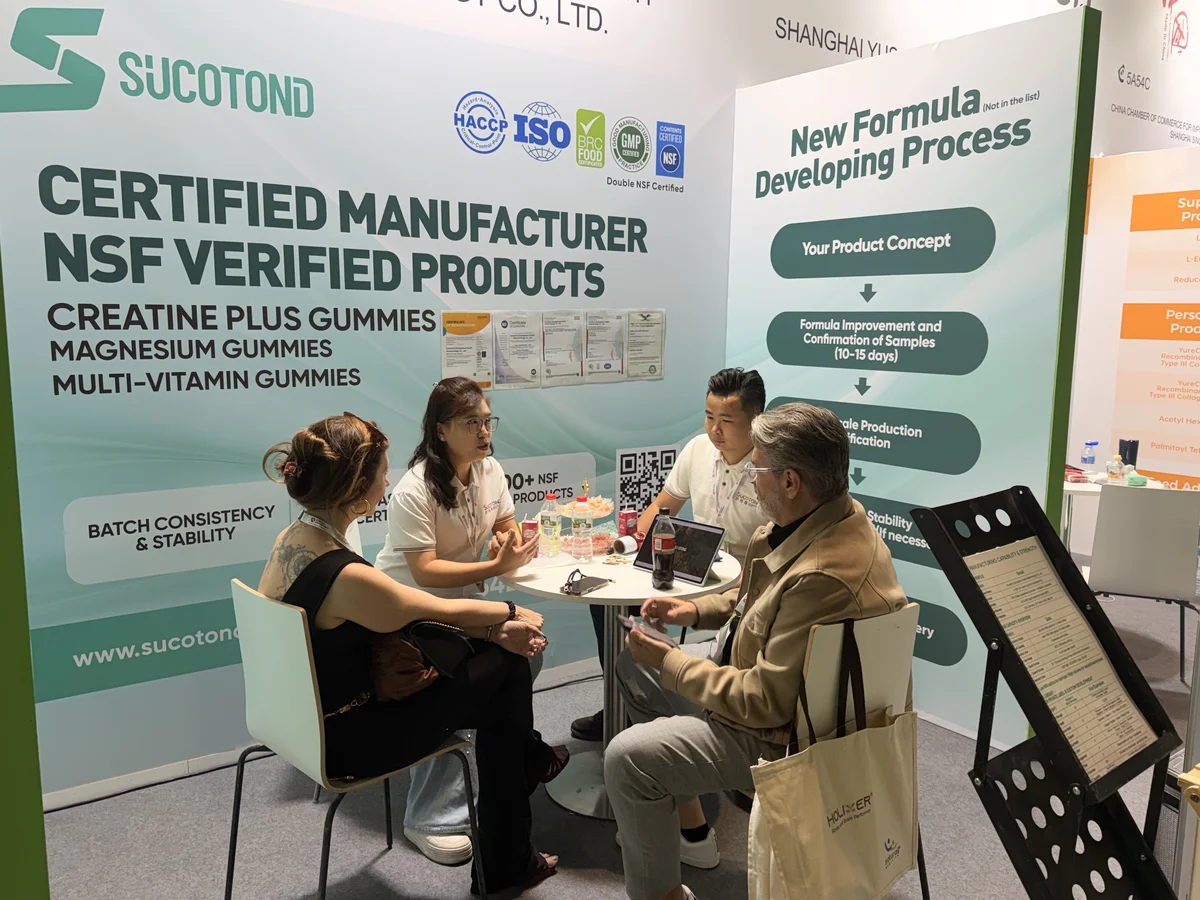 SUCOTOND representatives discuss gummy products with visitors at the stand table