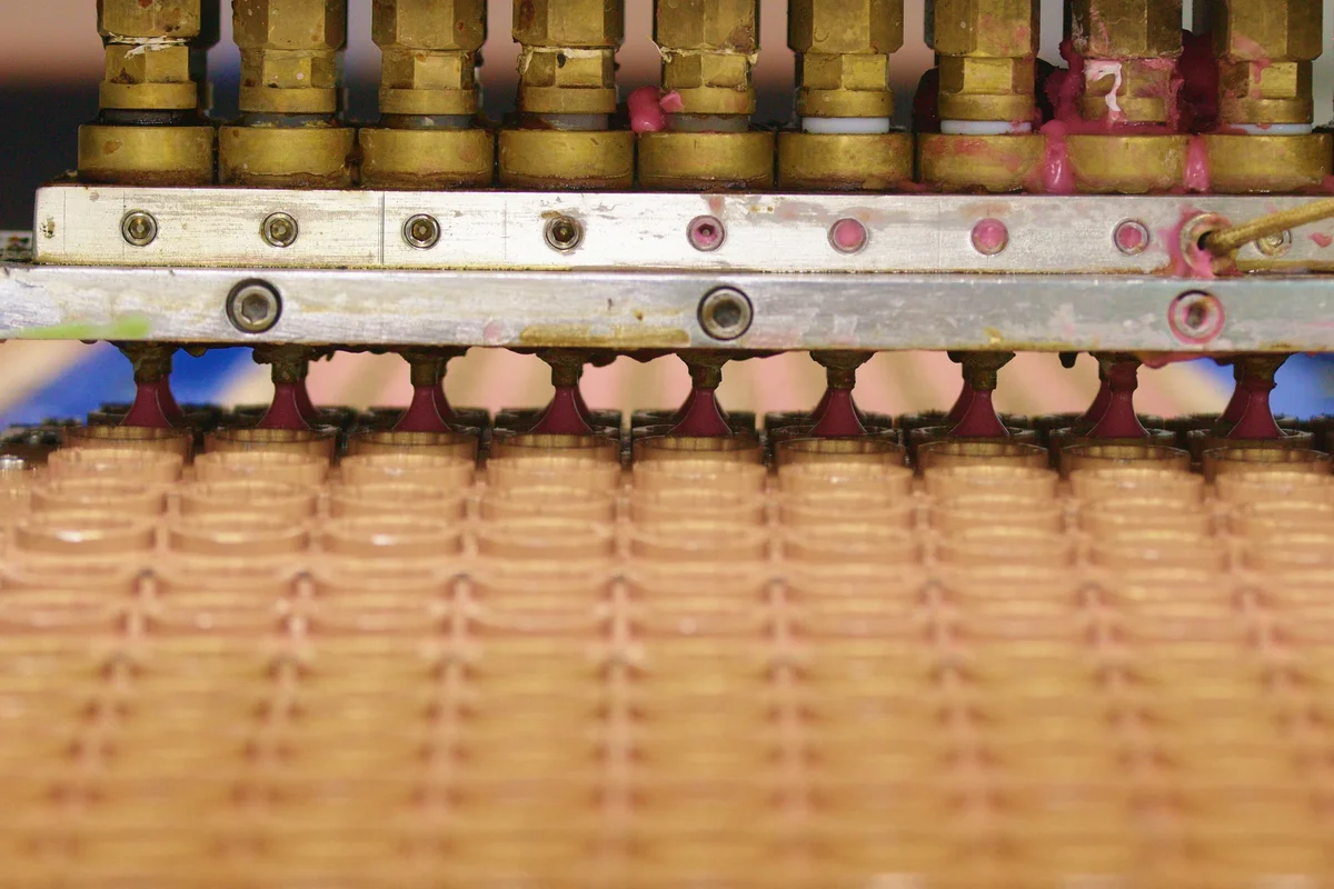 Depositing nozzles above rows of gummy molds on a production line