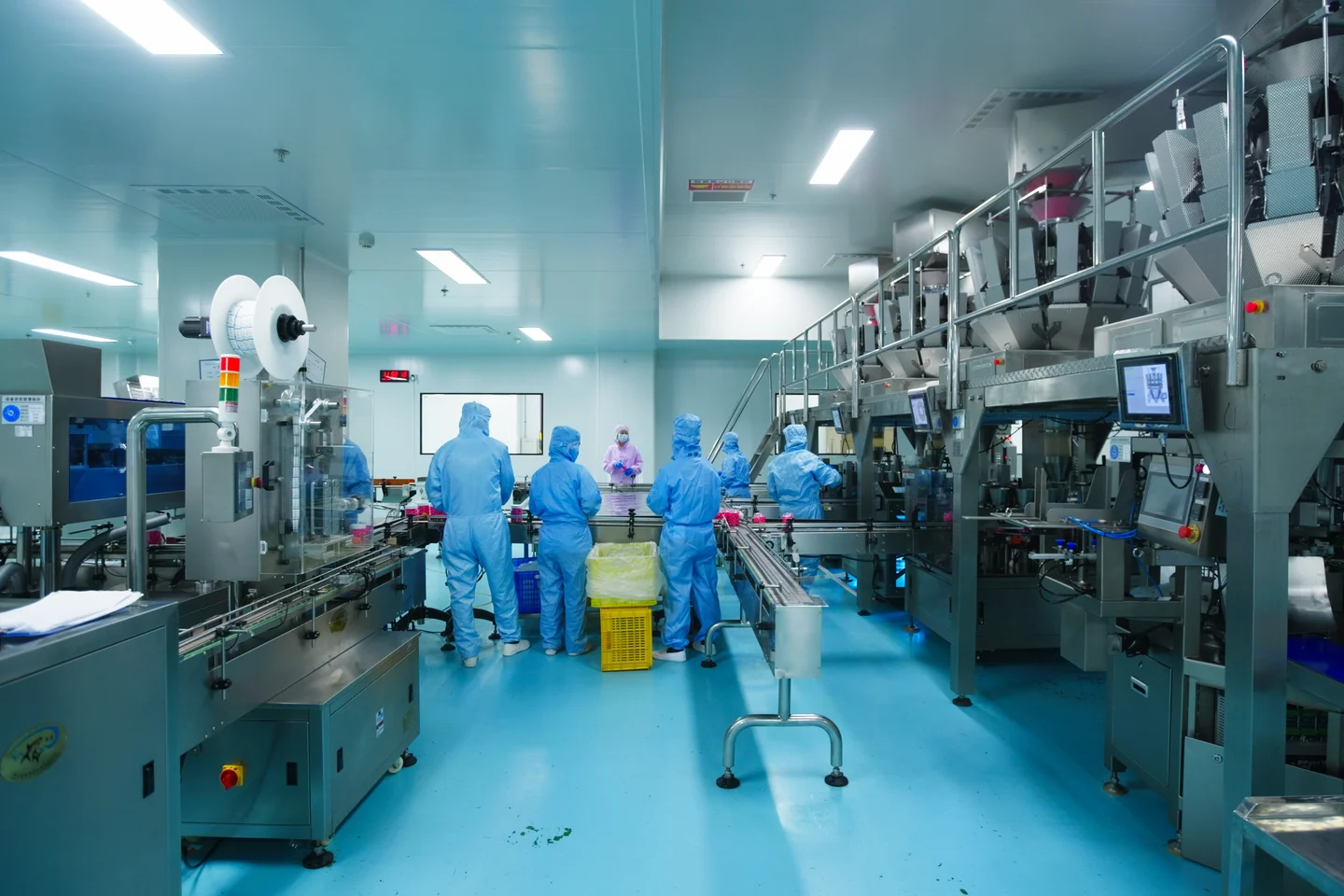 Workers and equipment in a gummy bottling and packing area