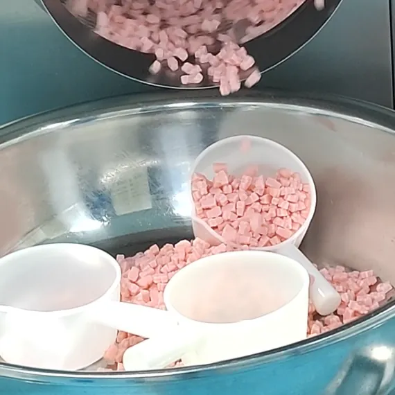 Pink gummies tumbling during anti-stick finishing for sugar-free apple cider vinegar gummies