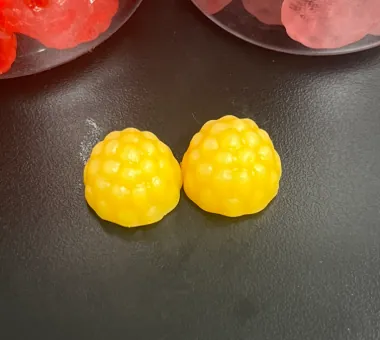 Two yellow berry-shaped ashwagandha root extract gummies representing a high-content 600 mg-per-serving private label formula using a brand-specified raw material supplier when required.