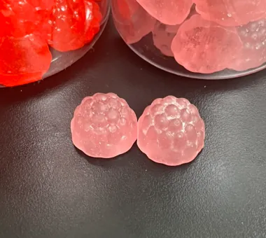 Two pale pink berry-shaped sugar-free ashwagandha gummies sweetened with erythritol and maltitol, with no added sucrose for zero-sugar and lower-calorie product positioning.