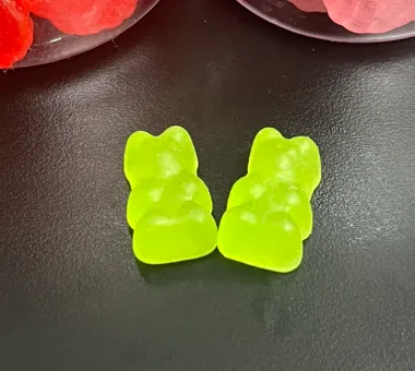 Two green bear-shaped vegan ashwagandha gummies made with a pure pectin system and no animal-derived ingredients for clean-label, vegan, Halal or Kosher certification projects.