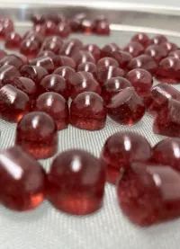 Dark red ashwagandha L-theanine relaxation gummies on a production screen, representing a private label product concept for the daily stress and physical relaxation market.