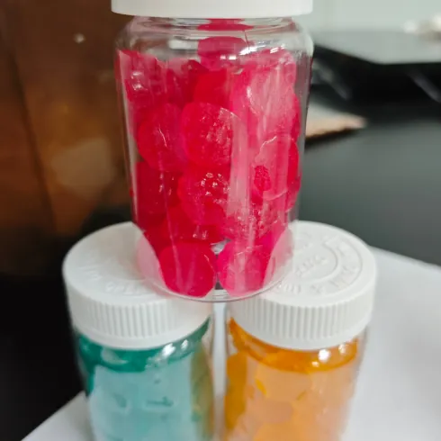 Jars of red and other gummy samples prepared for finished-product batch comparison