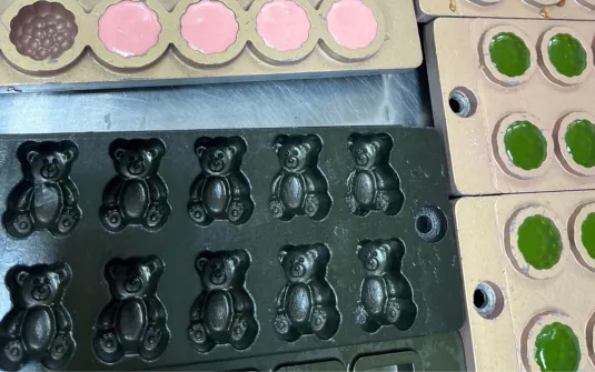 Different colored gummy mold samples arranged for a beetroot extract formulation comparison
