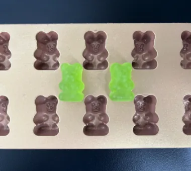 Green and purple high potency biotin gummy samples representing microencapsulated biotin designed to reduce processing exposure to temperature and pH and support shelf-life stability.