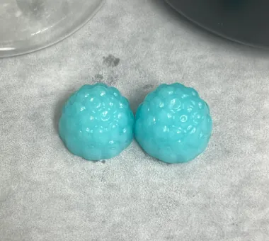 Two blue berry-shaped Blueberry Creatine D3 K2 Gummies, flavored with a small amount of raspberry to enrich the fruit profile and help balance creatine’s powdery taste.