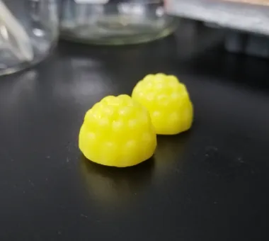 Two yellow berry-shaped creatine and collagen gummies with vitamin D3 and K2, developed as a compound women’s healthy aging formula with odorless collagen for skin-support positioning.