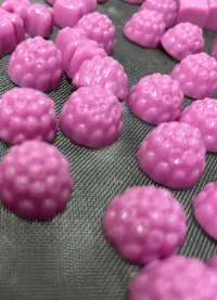 Pink berry-shaped all-pectin D3 K2 Creatine Gummies on a production belt, developed without animal-derived ingredients for clean-label, Vegan, Halal and Kosher certification applications.