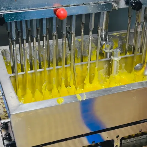 Yellow gummy mass is deposited into molds during creatine mineral gummy process evaluation