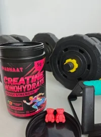 Assorted creatine gummy samples displayed with creatine powder, a shaker bottle, dumbbells, and an athlete in a gym