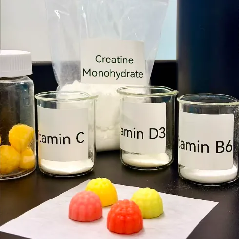 Creatine monohydrate, vitamin ingredients and multicolor gummy samples for Daily Creatine Gummies made with 99% pure creatine and fully chelated magnesium glycinate.