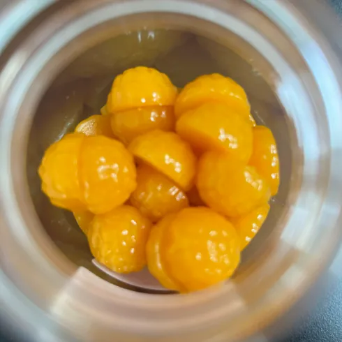 Yellow gummy samples viewed from above inside an open sample jar