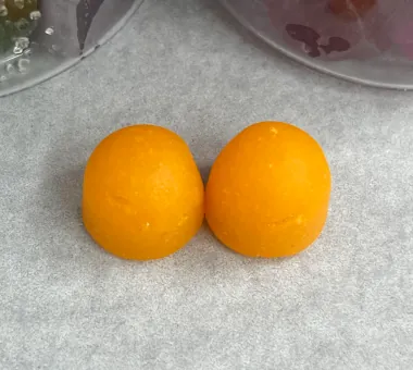 Two orange dome-shaped gummy samples illustrating a caffeine energy gummies option
