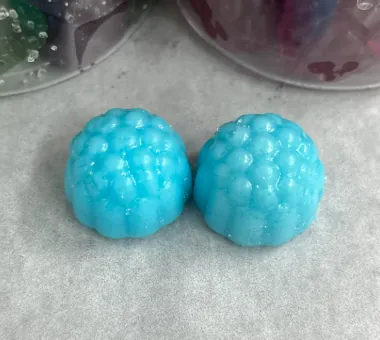 Two blue berry-shaped gummy samples illustrating a caffeine and L-theanine option