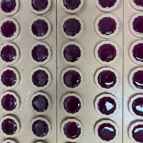 Purple gummy samples in a production mold for hair gummy development