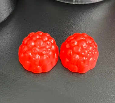Two red berry-shaped gummy samples illustrating a biotin hair gummy option