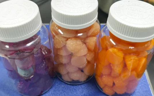 Three jars of differently colored gummy samples for a formula option