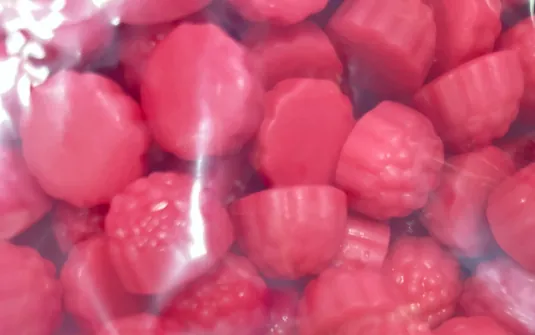 Pink berry-shaped gummy samples grouped inside a clear sample bag