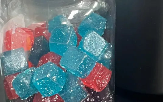 Mixed-color gummy samples in a clear reference jar