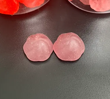 Two pale pink round sugar-free magnesium glycinate gummies made with maltitol, erythritol or similar sweeteners for low-calorie and zero-carb label-claim projects.