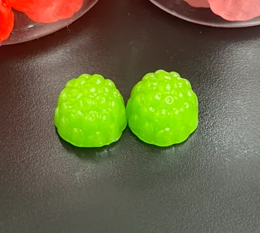Two green berry-shaped vegan magnesium glycinate gummies made with pectin for clean-label private label projects supporting vegan, Halal or Kosher label-claim applications.