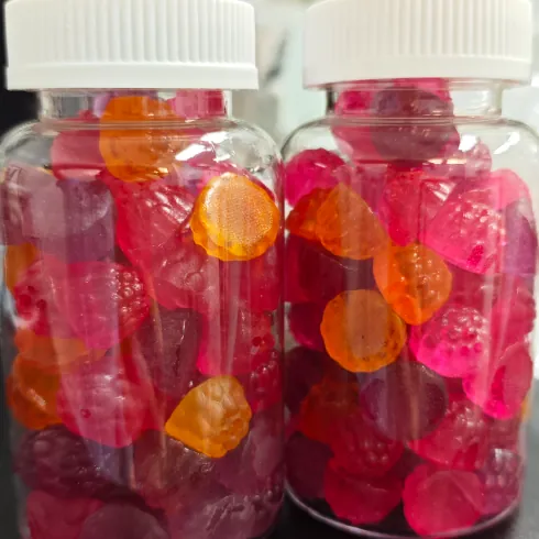 Bottled pink and orange probiotic gummy samples representing one-stop private label service from formulation and mass production to packaging, shipping and stage-by-stage records.
