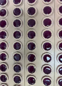 Purple gummy samples in production molds for a protein gummies for women project combining protein with saffron and light vanilla flavor for stress and menstrual-support product positioning.