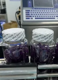 Purple bottled gummies on a production line for a sea moss and bladderwrack batch-development case