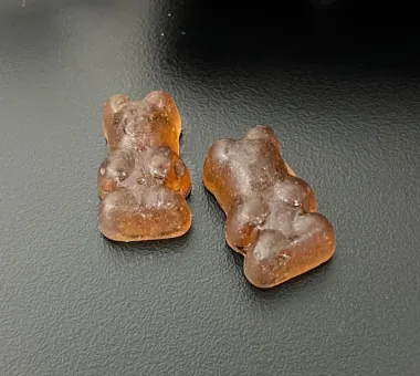Two brown bear-shaped gummy samples displayed for the Shilajit Gummies for Men product concept