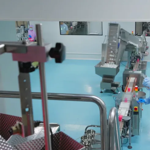 Production operator working beside gummy processing equipment during formulation development