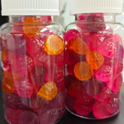 Different colored gummy samples in clear jars during superfood gummy formula development