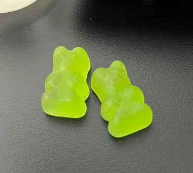 Two green bear-shaped gummy samples for a super greens gummy product concept