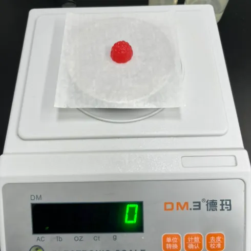 Gummy sample on a precision scale during laboratory preparation for turmeric curcuminoid testing