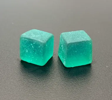 Two blue cube gummies displayed individually for a dispersible curcumin gummy concept