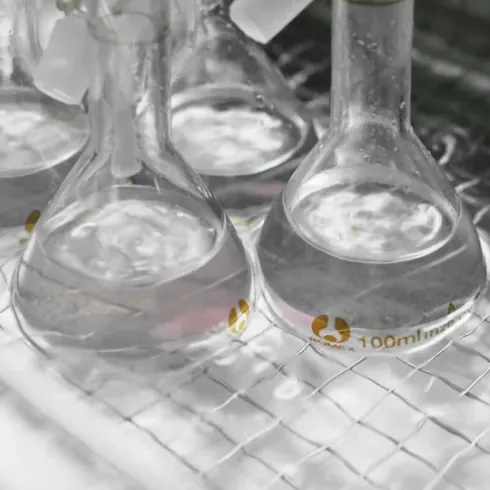 Laboratory flasks used during incoming verification of vitamin raw materials, with testing procedures selected according to each ingredient type before use in vitamin gummy production.