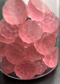 A jar of pale pink berry-shaped sugar-free vitamin gummies representing formulas sweetened with maltitol or erythritol, with pure pectin available for vegan private label projects.
